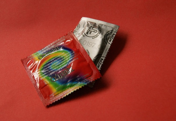 Tie dye condom packages on red background