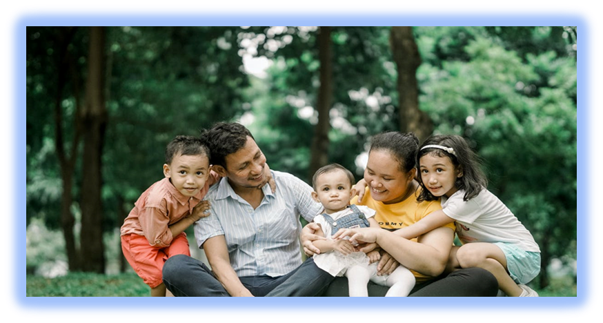 Smiling family of Five sitting in a park