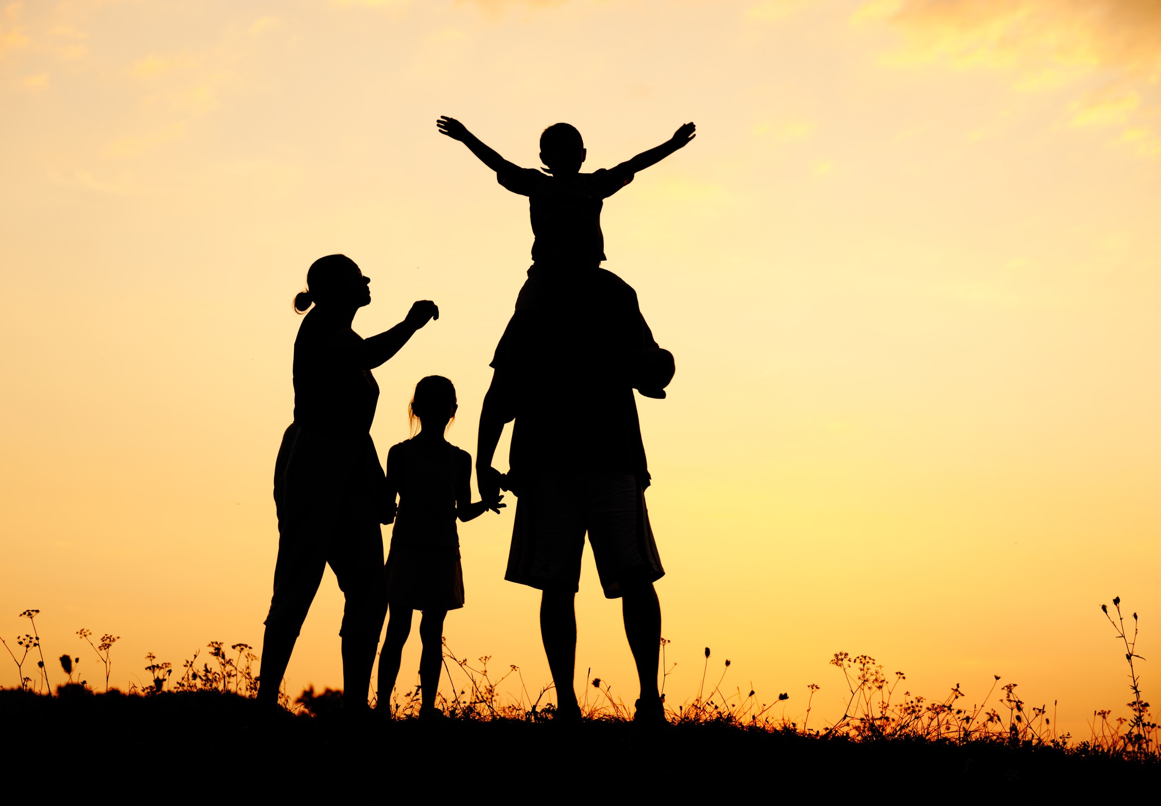 Family standing in a sunset.