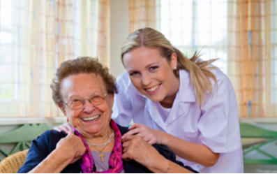 Caregiver taking a picture with an elderly woman.