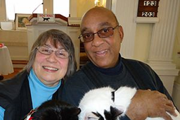 Couple taking a photo with their cat.