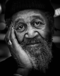 black and white photo of man resting his head in his hand 