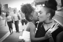 Black and white photo of parent and child hugging and kissing.