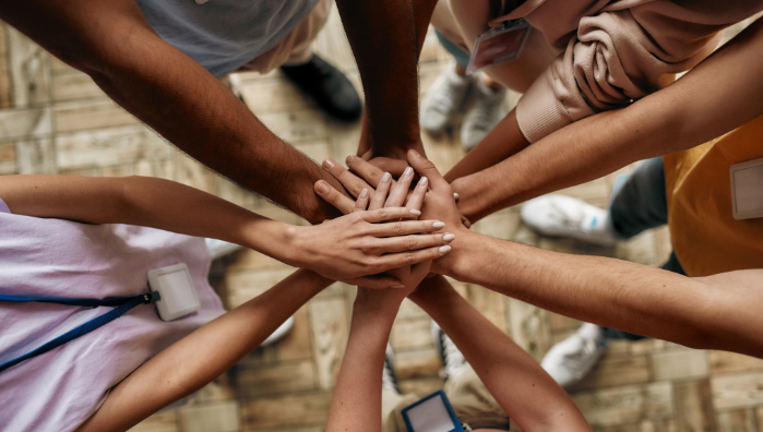 Group of community members joining hands in a circle, representing provider collaboration